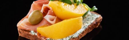 panoramic shot of ham and canned peaches on cooked danish smorrebrod sandwich on blackの写真素材