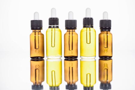 bottles of natural serum on surface with reflection isolated on whiteの写真素材