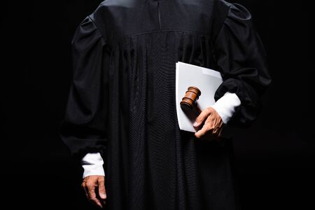 cropped view of judge in judicial robe holding gavel and papers isolated on blackの写真素材