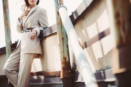 cropped view of stylish girl posing in beige suit on urban roofの写真素材