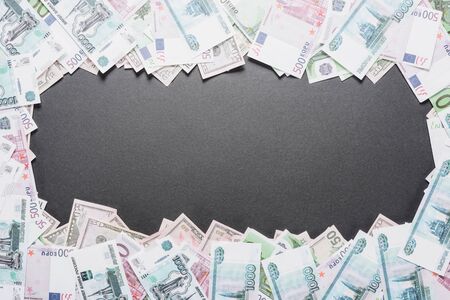 top view of empty frame of dollar, euro and ruble banknotes on black background with copy spaceの写真素材