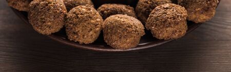 close up view of falafel balls on plate on wooden table, panoramic shotの写真素材
