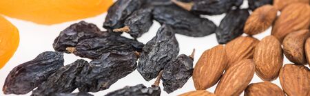 close up view of almonds, raisins and dried apricots isolated on white, panoramic shotの写真素材