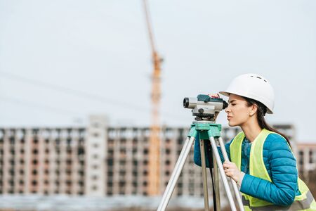 Side view of Surveyor working with digital levelの写真素材
