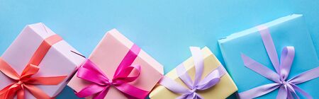 top view of colorful gift boxes on blue background, panoramic shotの写真素材