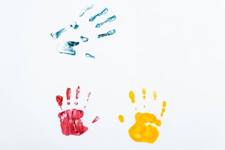 red, blue and yellow hand prints on whiteの写真素材