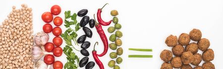 top view of chickpea, garlic, cherry tomatoes, parsley, olives, chili pepper, green onion and falafel on white background, panoramic shotの写真素材