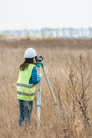 Back view of surveyor working with digital level in fieldの写真素材