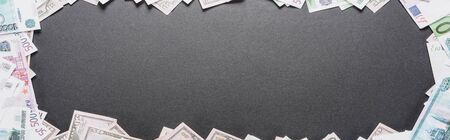panoramic shot of empty frame of dollar and euro banknotes on black background with copy spaceの写真素材