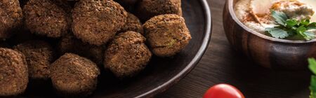 close up view of falafel balls near hummus on wooden table, panoramic shotの写真素材