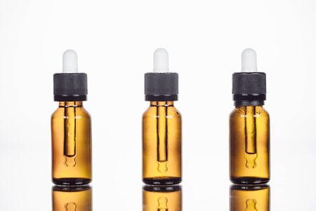 bottles of organic serum on surface with reflection isolated on whiteの写真素材