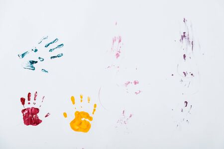 blue, red and yellow hand prints on whiteの写真素材