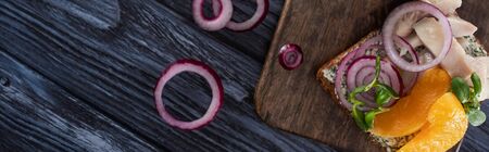 panoramic shot of rye bread with tasty smorrebrod sandwich on blue wooden surfaceの写真素材