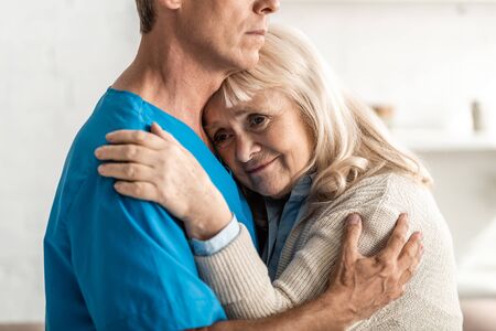 cropped view of doctor hugging sick senior womanの写真素材