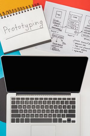 top view of notebook with prototyping lettering, laptop and website design template on abstract geometric backgroundの写真素材