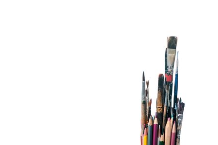 colorful pencils near paintbrushes isolated on whiteの写真素材