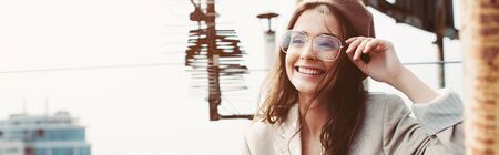 attractive smiling model posing in beige suit and beret on urban roofの写真素材