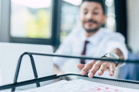 selective focus of businessman taking paper from documents trayの写真素材