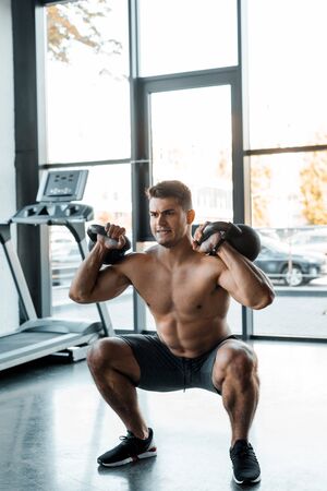handsome sportsman working out with weights in sports centerの写真素材