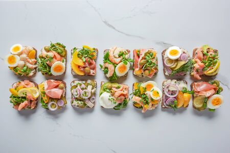 top view of delicious danish smorrebrod sandwiches on white marble surfaceの写真素材