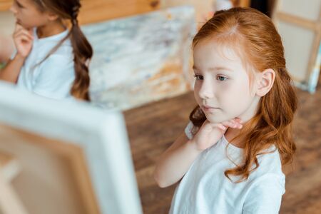 selective focus of pensive kids in art school