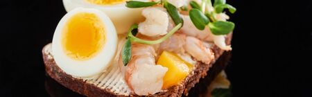 panoramic shot of rye bread with delicious shrimps on smorrebrod sandwich on blackの写真素材