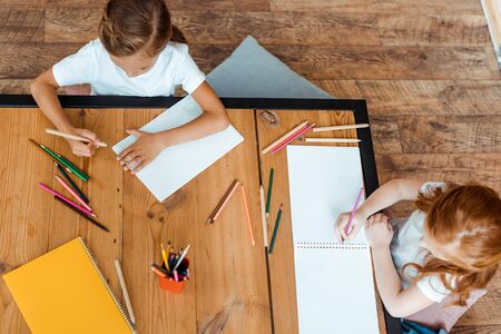 top view of cute kids drawing on papersの写真素材