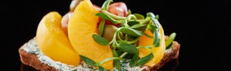 panoramic shot of canned peaches on danish smorrebrod sandwich on blackの写真素材