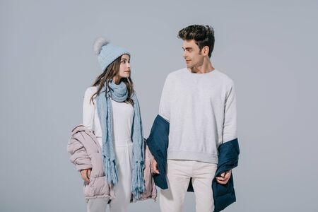 beautiful stylish young couple posing in warm winter outfit, isolated on greyの写真素材