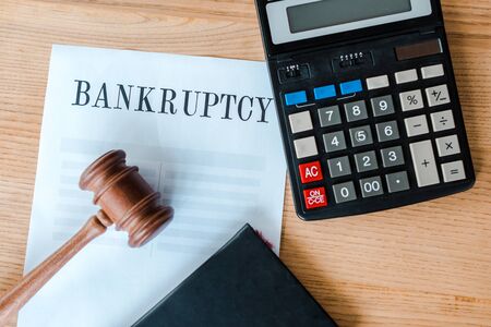 top view of document with bankruptcy letters near calculator and gavel