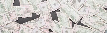 top view of scattered dollar banknotes on black background, panoramic shot