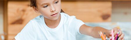panoramic shot of cute kid taking color pencils