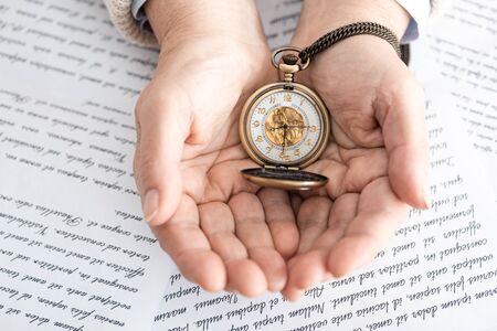top view of senior woman holding compass near papers with letters