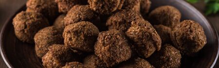 close up view of fresh cooked falafel balls on wooden table, panoramic shot