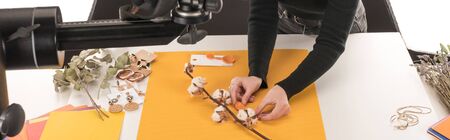 cropped view of photographer making composition with cotton flower and accessories for photo...