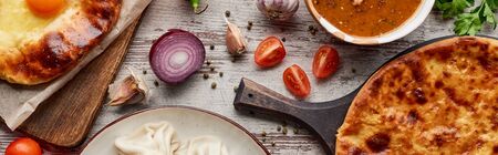 Aadjarian and imereti khachapuri, khinkali and soup kharcho on wooden texture, panoramic shotの写真素材
