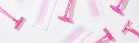 top view of pink razors and depilation wax stripes on white background, panoramic shot