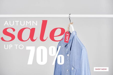 blue shirt hanging with sale label isolated on white with autumn sale, up to 70 percent illustrationの写真素材
