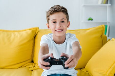 KYIV, UKRAINE - OCTOBER 2, 2019: selective focus of happy kid playing video game at home