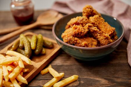selective focus of delicious chicken nuggets, french fries and gherkins on wooden tableの写真素材