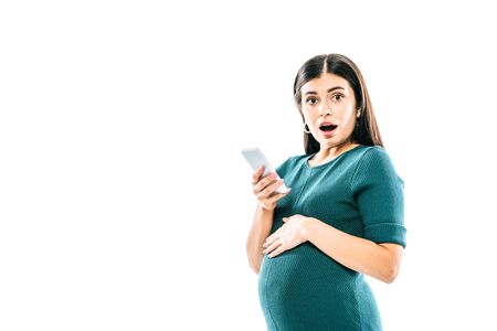 shocked pregnant girl using smartphone isolated on whiteの写真素材