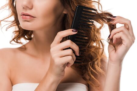 cropped view of girl brushing curly hair isolated on whiteの写真素材