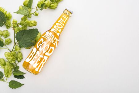 top view of beer in bottle with good people drink good beer lettering and green blooming hop on...