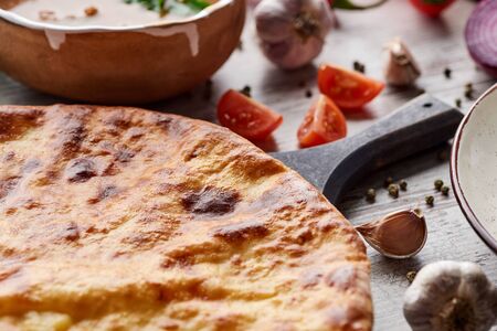 Traditional Georgian imereti khachapuri with vegetables and spices on tableの写真素材