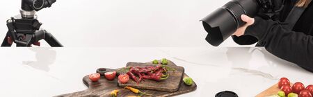 cropped view of female photographer making food composition for commercial photography and taking photo on digital cameraの写真素材