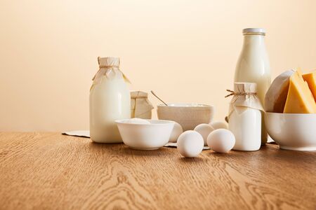 tasty organic dairy products and eggs on rustic wooden table isolated on beigeの写真素材