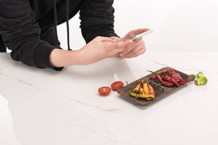 cropped view of photographer making food composition for commercial photography on smartphone
