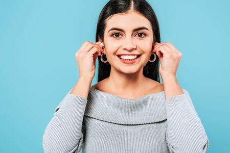 smiling pregnant pretty girl using wireless earphones isolated on blueの写真素材