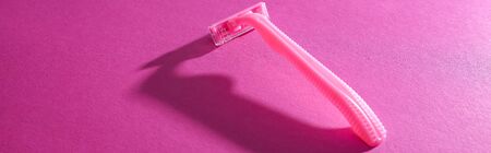 disposable feminine razor on pink background with copy space, panoramic shotの写真素材
