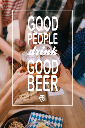 cropped view of multicultural friends clinking glasses of light beer in pub with good people drink good beer illustrationの写真素材
